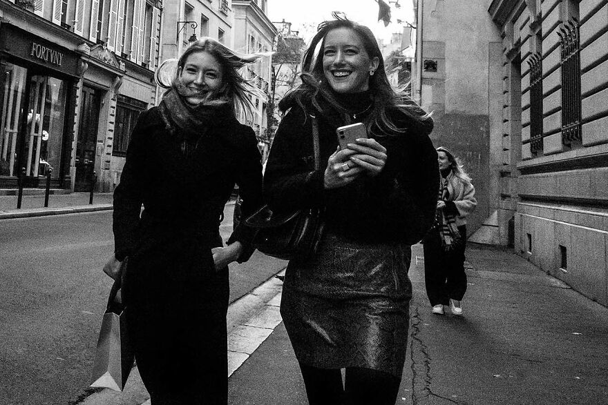 Two beautiful women walking and smiling on a city street, captured by photographers around the world.