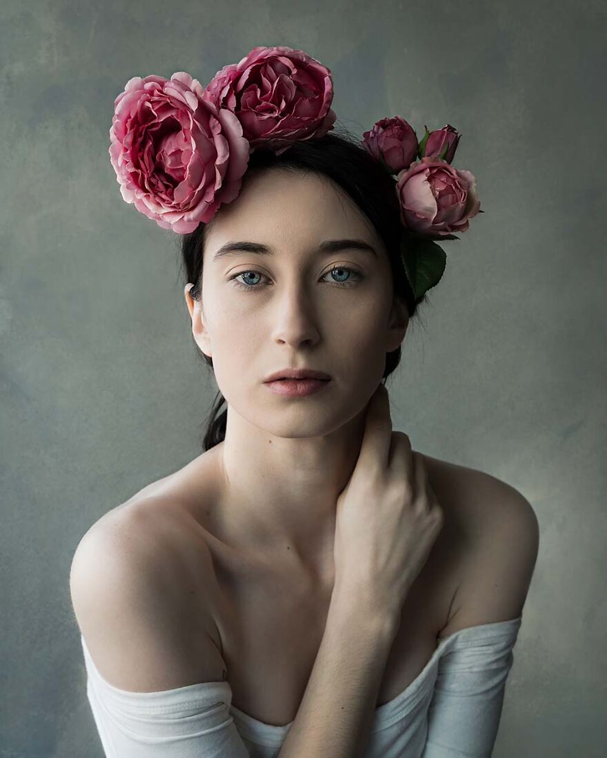 Portrait of a beautiful woman with pink flowers in her dark hair, captured by photographers showcasing global beauty.