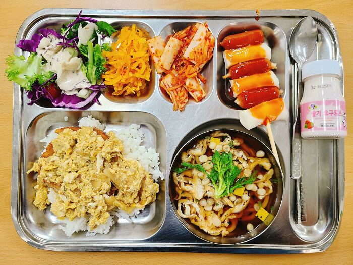 Almuerzo escolar coreano de Udon, huevo y chuleta de cerdo deopbap y varios banchan