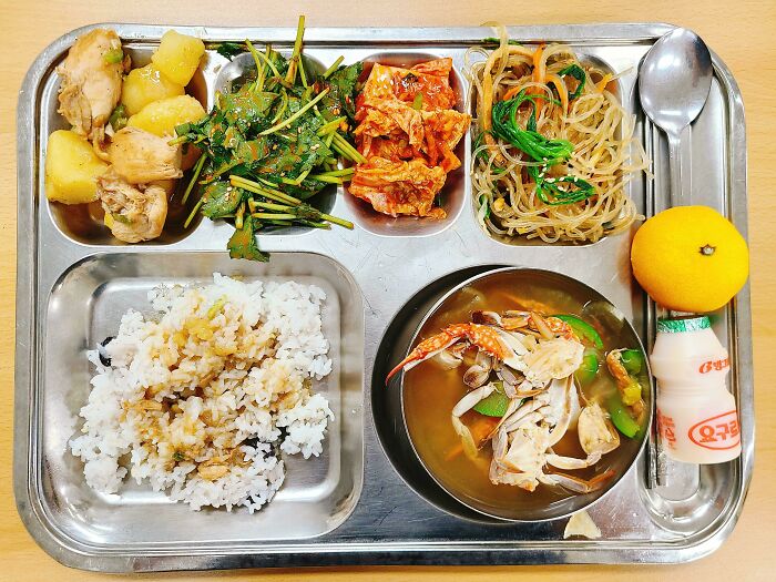 Mi almuerzo escolar coreano de sopa de cangrejo, pollo guisado y papas y varios banchan