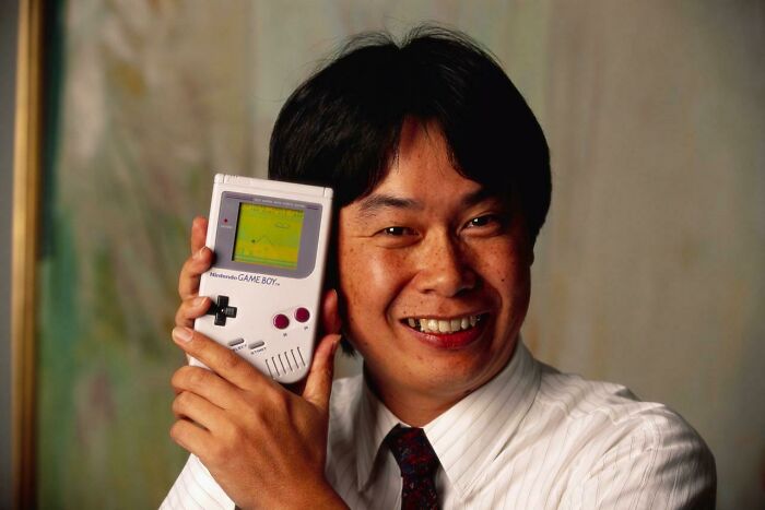 Shigeru Miyamoto, Creator Of Mario And Other Characters And Video Games For Nintendo, Holds A Nintendo Game Boy Containing The Super Mario World Video Game. June 1992