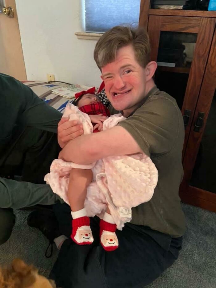 Mi hermano con síndrome Down sosteniendo a su sobrina nieta recién nacida en Navidad
