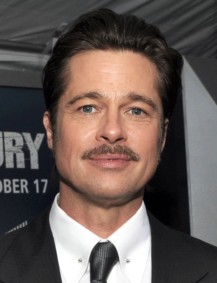 Close-up of a popular actor with a mustache, wearing a black suit and tie at a formal event promoting a movie. Close-up of a popular actor with a mustache, wearing a black suit and tie at a formal event promoting a movie.