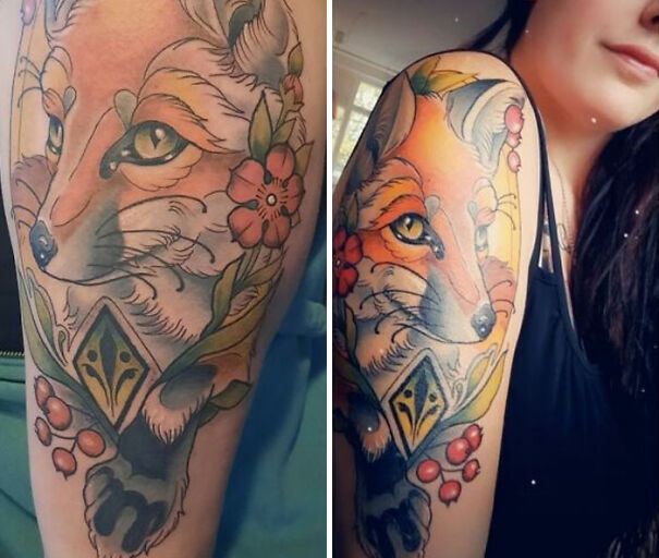 Colorful fox tattoo surrounded by flowers and leaves on a woman's upper arm, showcasing impressive new tattoo art.