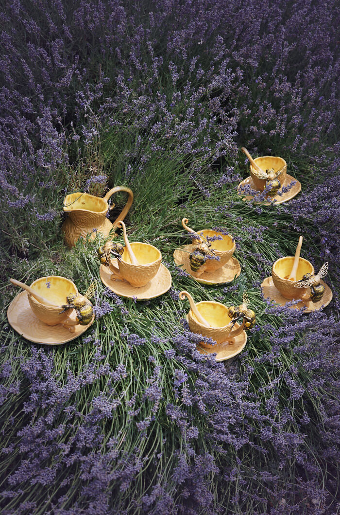 Nature-inspired ceramics set with bee motifs displayed on lavender plants.