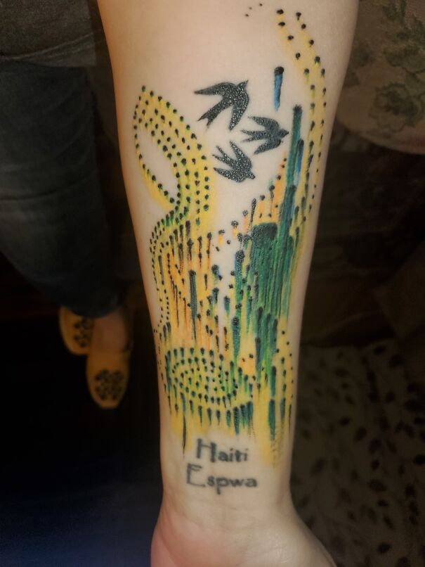 New tattoo featuring abstract design with birds and "Haiti Espwa" text on forearm.