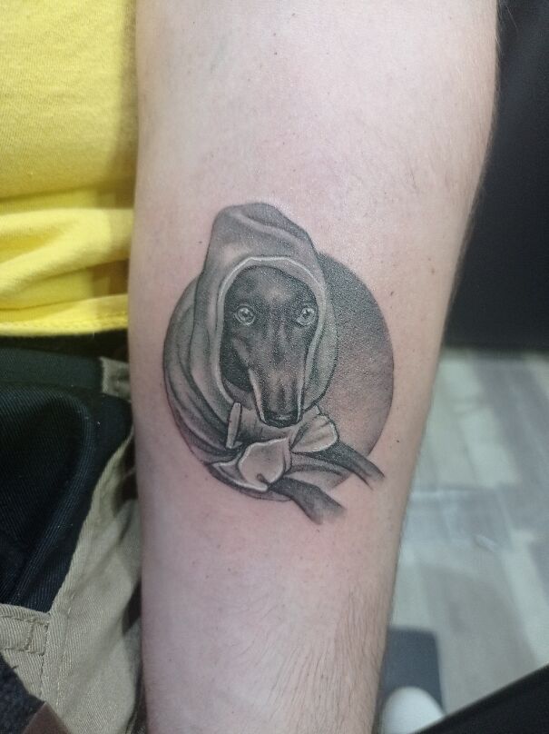 A detailed, impressive new tattoo of a dog in a hood on a forearm.
