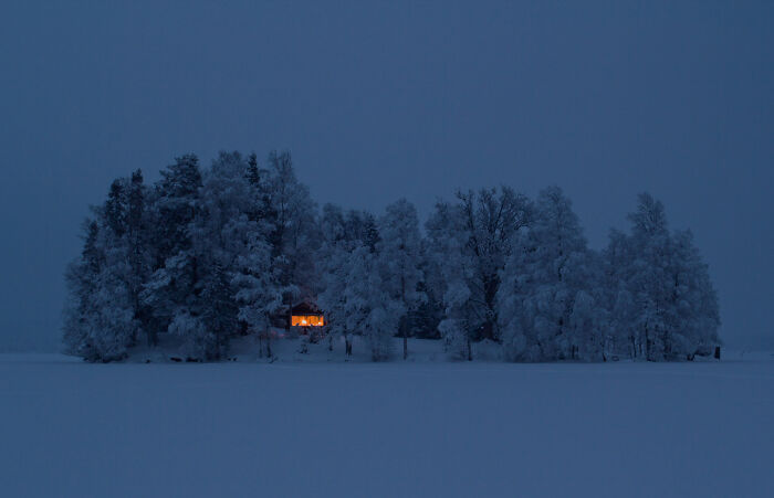 Esta cabaña escondida entre los árboles durante un noche de invierno