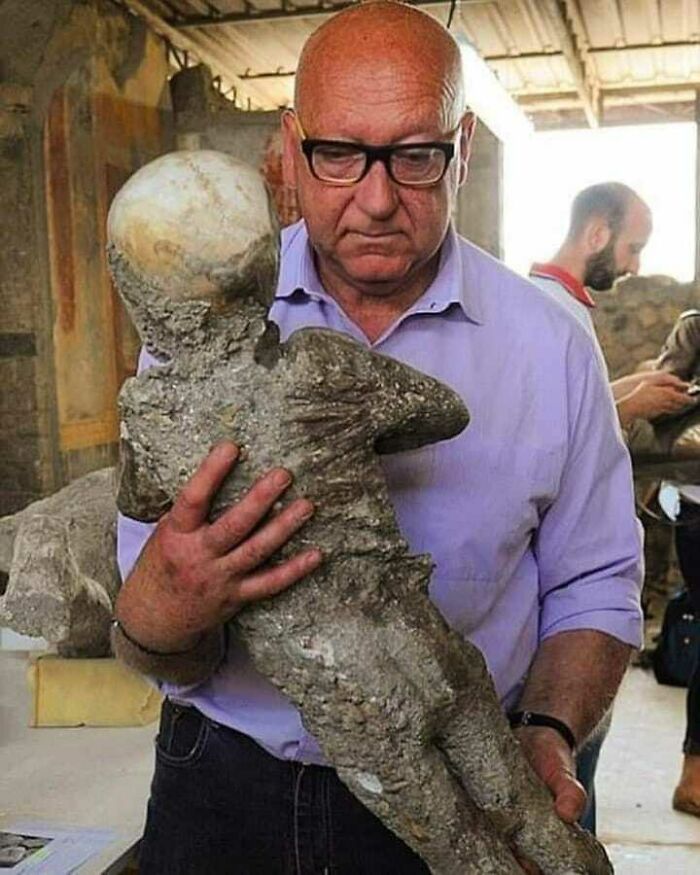 Un arqueólogo sosteniendo el cadáver fosilizado de un niño de Pompeya