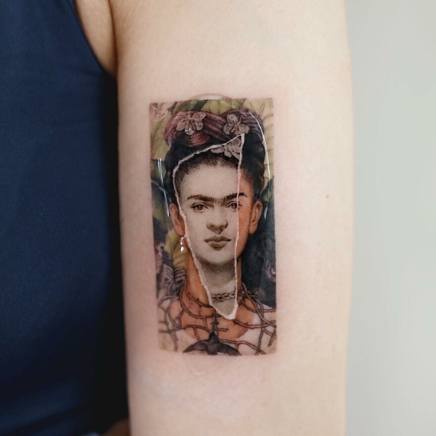 A painting-like tattoo on an arm, depicting a split portrait of a woman with flowers in her hair.