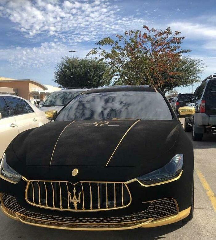 A Maserati With Black Suede In The Parking Lot Of A Walmart