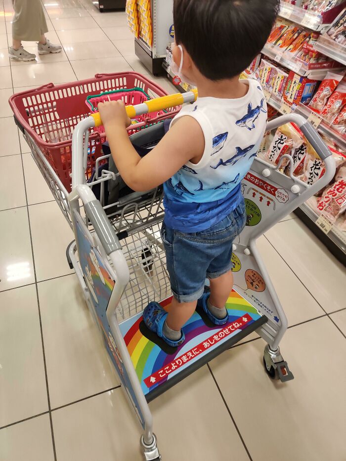 Carro de la compra con un lugar para que se pongan los niños de pie mientras los padres empujan