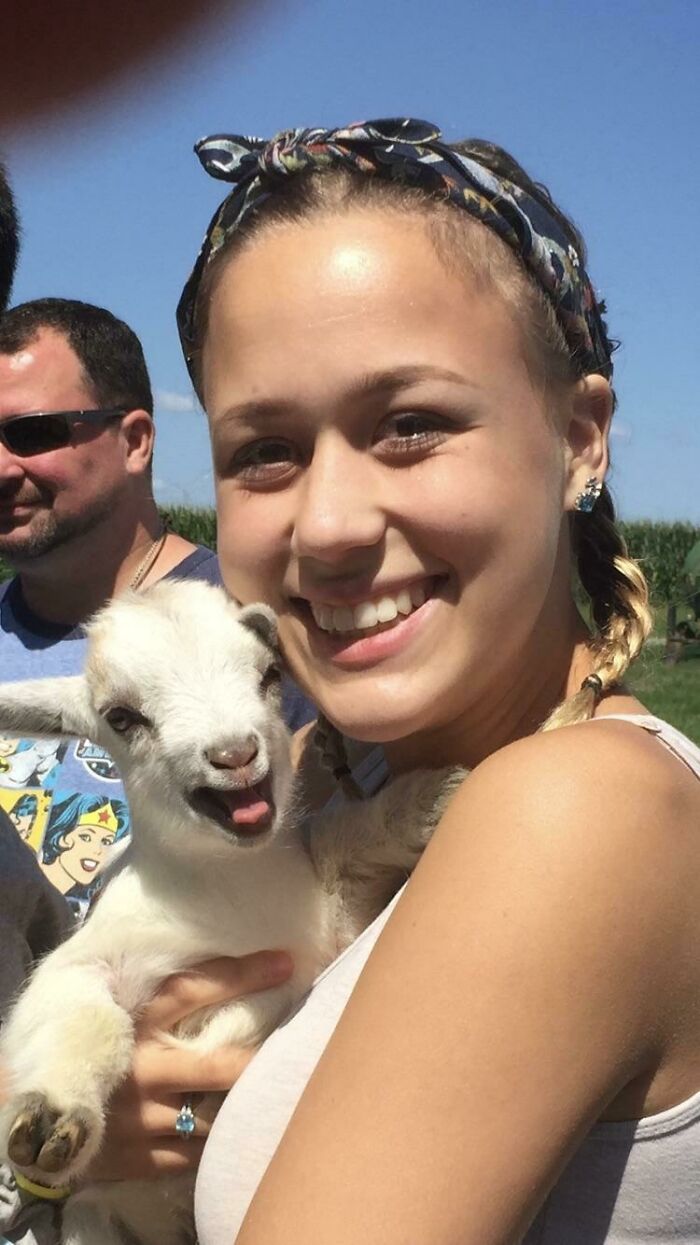 girl holding a white baby goat