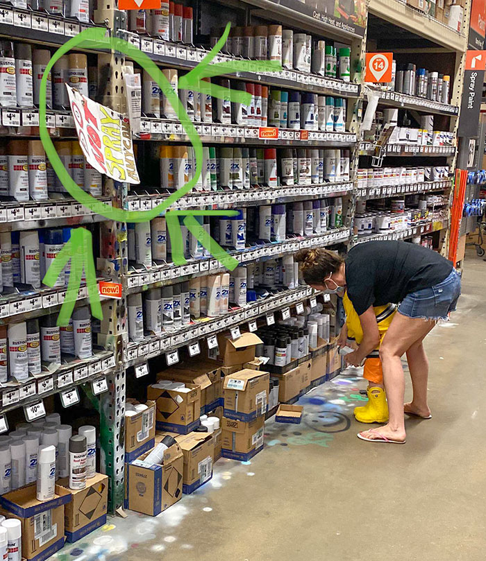 Solo es una madre enseñándole a su hijo cómo pintar el suelo de la tienda con aerosol
