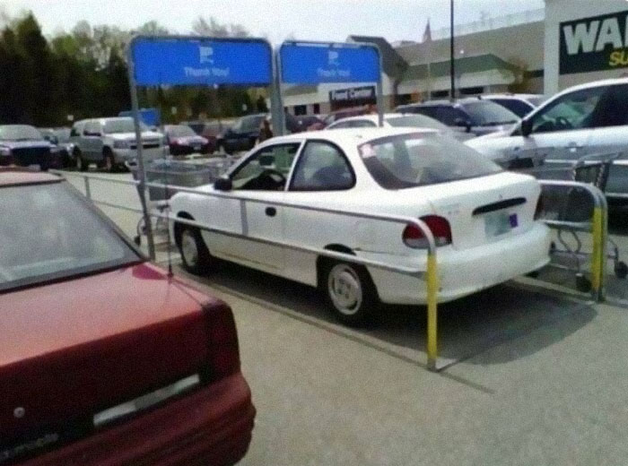 Small white car parked in an empty cart-rack 
