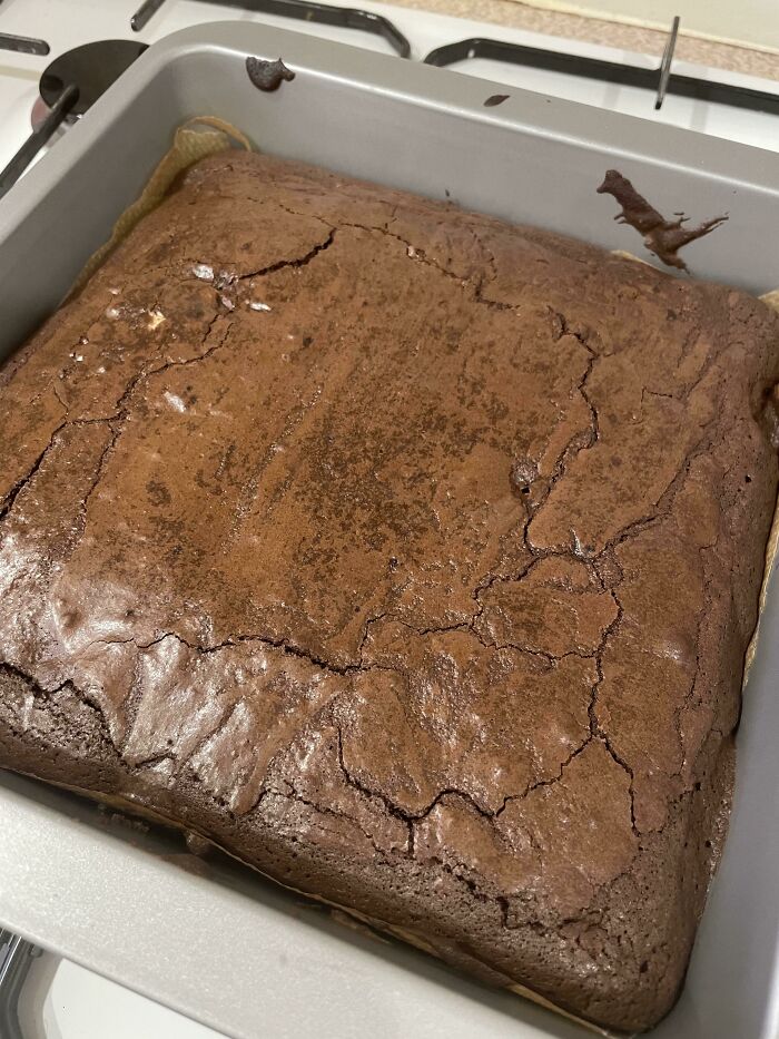 I Baked Brownies And On The Side Of The Pan It Looks Like There’s A Dinosaur Diving Into Them