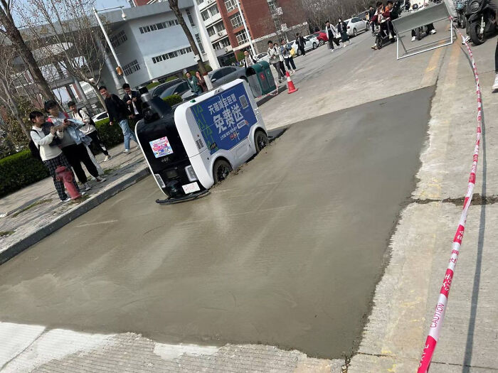 Un robot de reparto intenta avanzar por el cemento sin secar