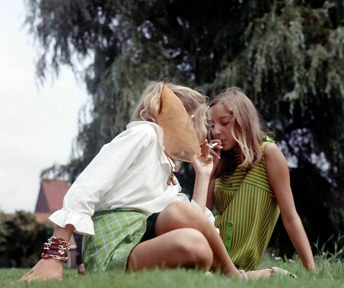 Two Young Teen Girls Smoking Cigarettes In The Grass. Photographed By Henk Hilterman In 1969