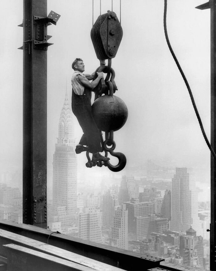 An Empire State Builder Hanging On A Crane Above New York City, 1930