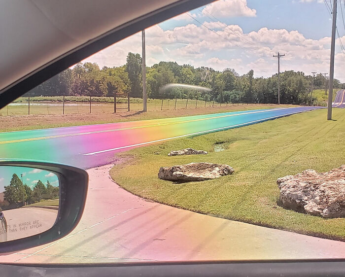 Da el sol en esta carretera recién asfaltada y parece un arco iris a través de lentes polarizadas
