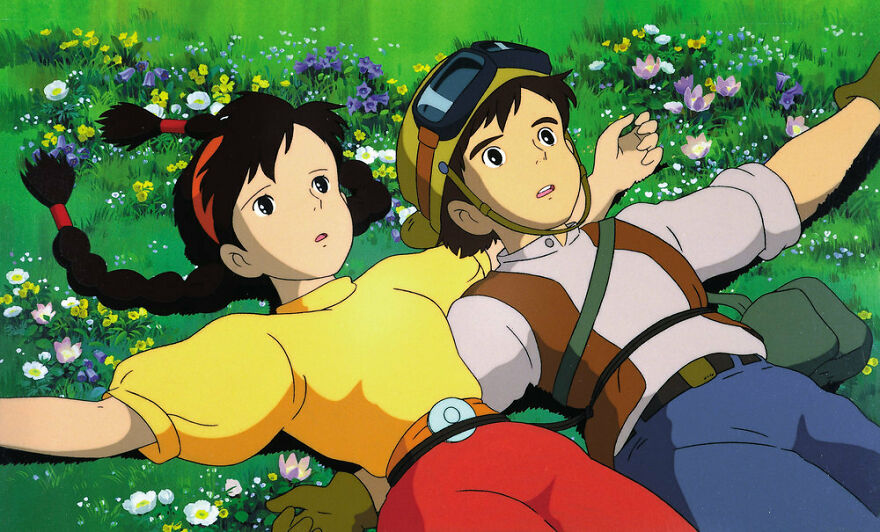 A cartoon young couple lies down on the grass with many flowers