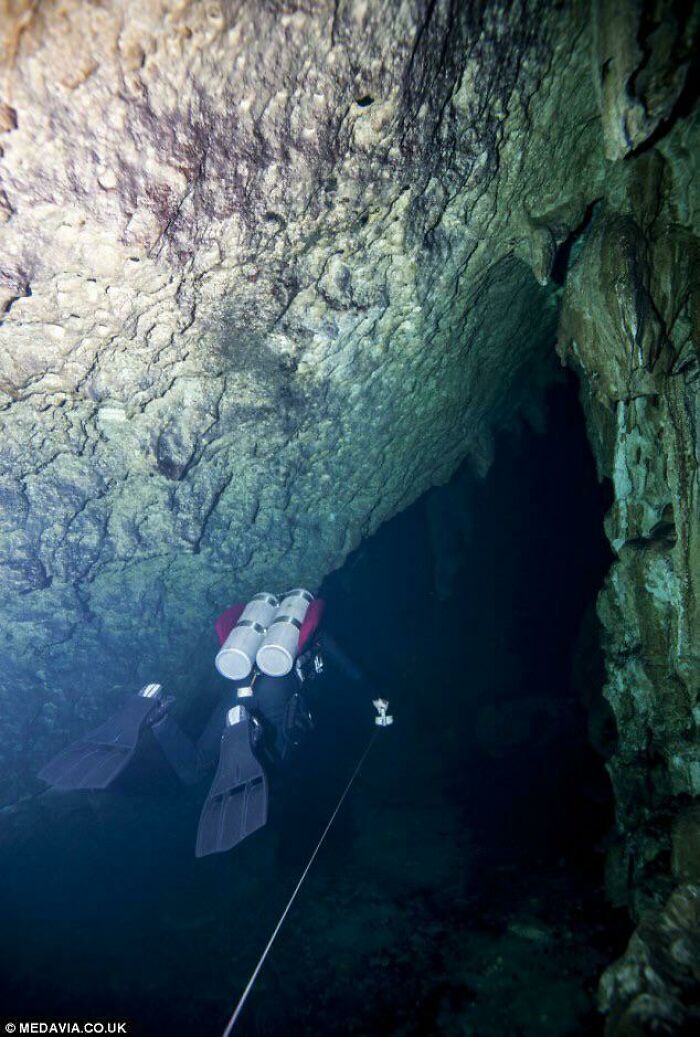 A Scuba Diver Proceeding Into An Underwater Cave