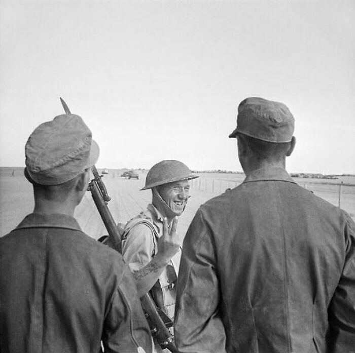 A British Soldier Gives A V-For-Victory Sign To German Prisoners Captured At El Alamein, 26 October 1942