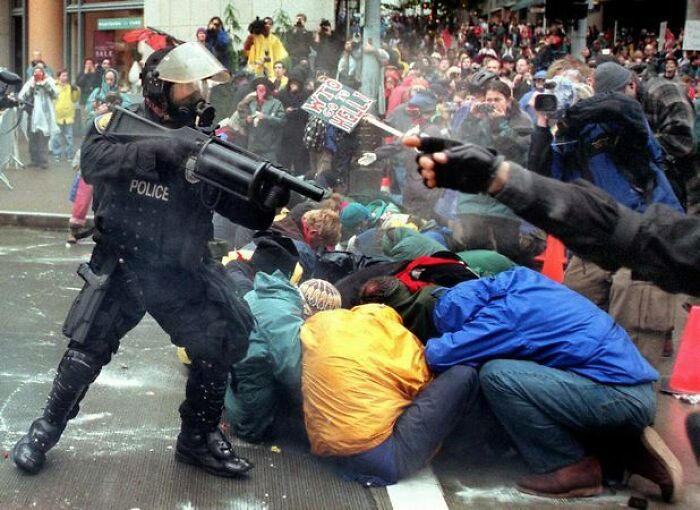 A Police Officer Fires Into A Group Of Demonstrators Attempting To Prohibit Access To The Wto During The "Battle Of Seattle." Nov 30, 1999