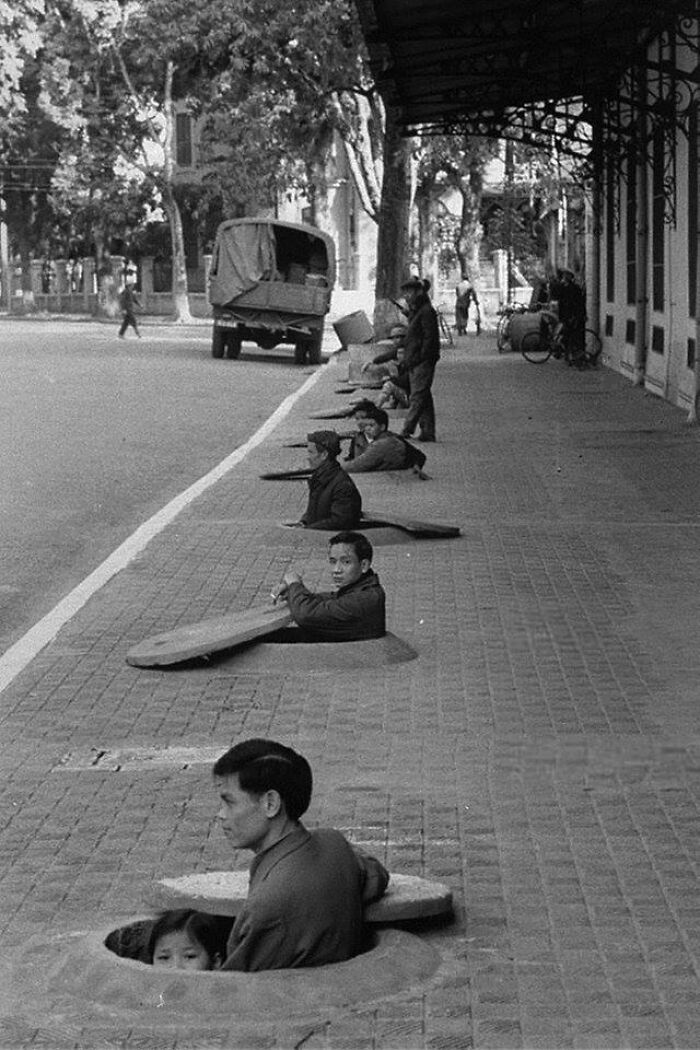 Residents Of Hanoi Wait In Chest-Deep Sidewalk Shelters For The All Clear Signal, During An Air Raid Alert. Hanoi, North Vietnam, 1967