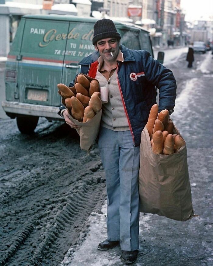 A Delivery Man With Bags Filled With Baguettes On A Snowy Street In Quebec, 1977