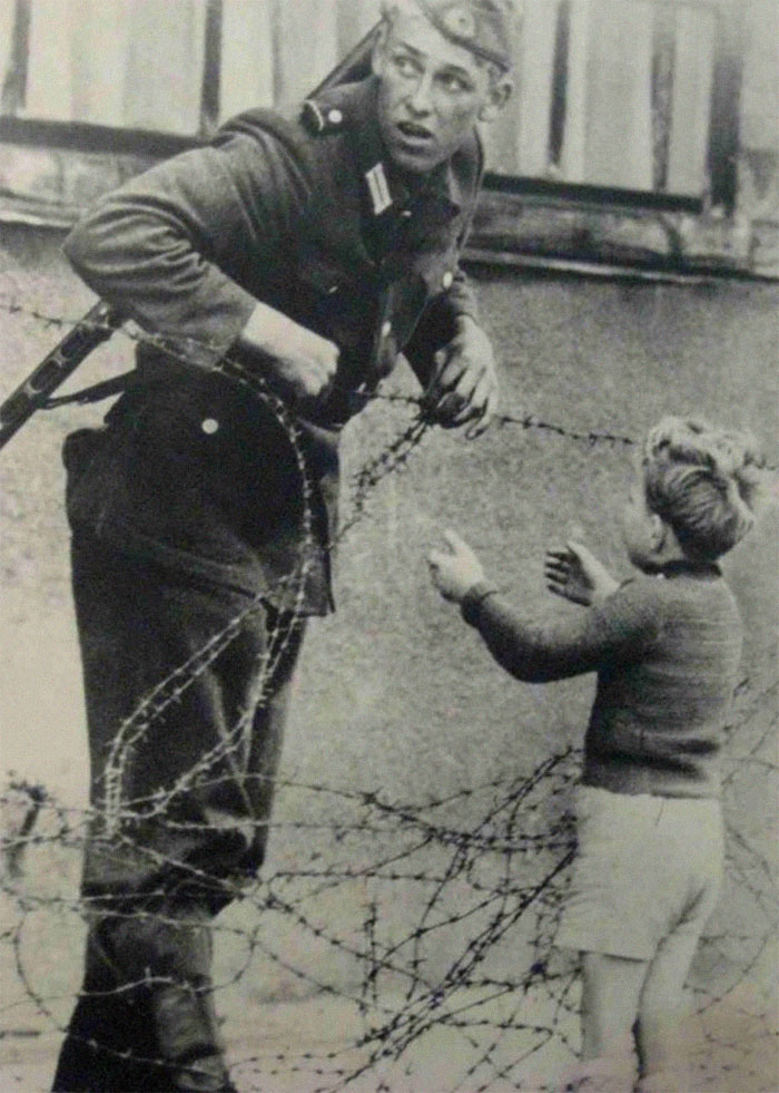 German Soldier Helps A Little Boy Sneak Across The Berlin Wall, 1961
