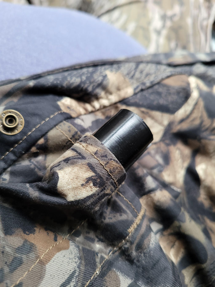 Small Cylinder Attached To Camouflage Hunting Jacket