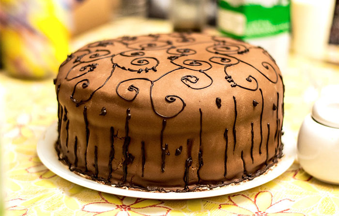 Brown cake with black decorations on a table 