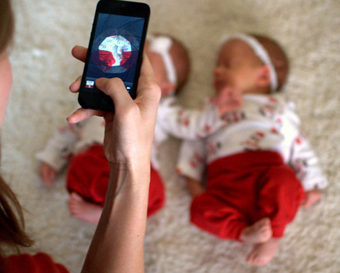 Woman Taking picture of her newborn baby in a cute outfit 
