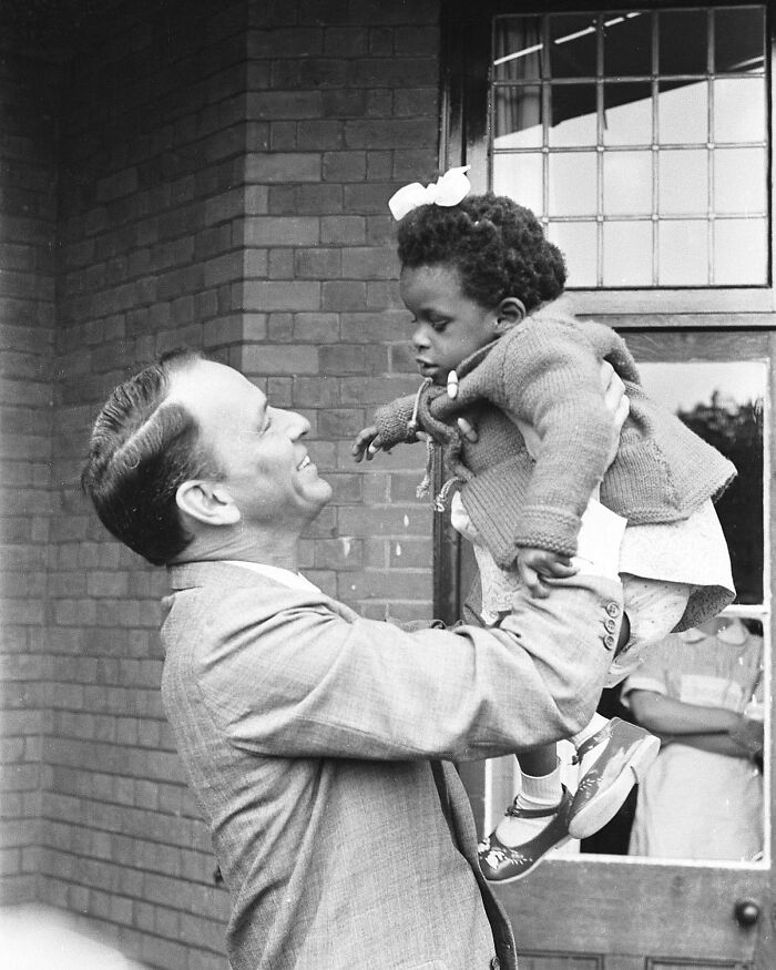 Frank Sinatra comparte un dulce momento con una niña durante su visita al Royal National College for the Blind School en Northwood, Middlesex, 1962