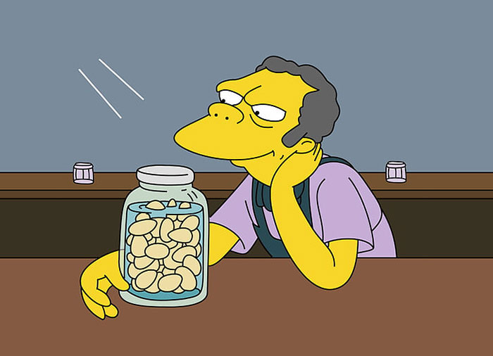 The Simpsons character Moe Szyslak is sitting at bar with a jar of eggs