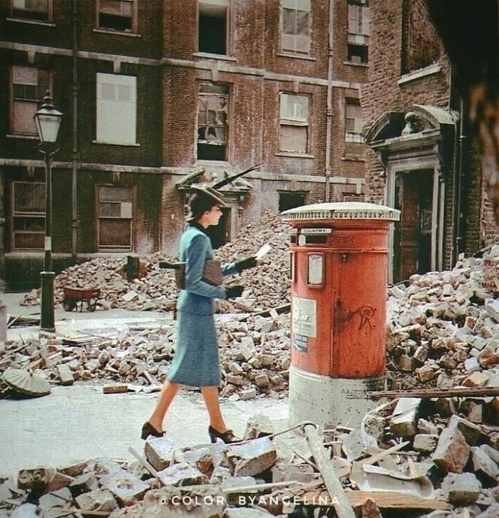 Una mujer que deposita una carta en un buzón entre edificios destruidos y escombros causados por los ataques aéreos alemanes durante la Segunda Guerra Mundial. Fotografía tomada en Londres, Reino Unido, en 1940