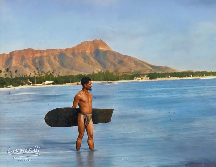 Un surfista hawaiano, Charles Kauha, llevando una Alaia, una tabla de surf montada en el Hawaii anterior al siglo XX, en la playa de Waikiki en 1898