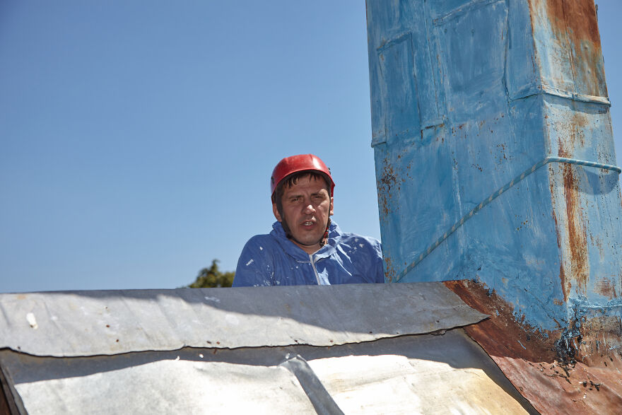 The Painter-Climber Paints The Chimney. A Worker On A Blue Sky Background.