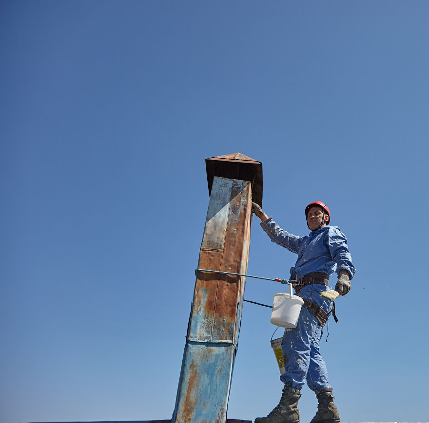 The Painter-Climber Paints The Chimney. A Worker On A Blue Sky Background.