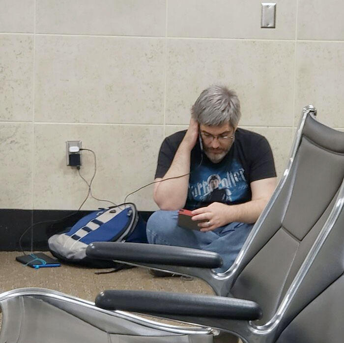 At The Airport Tonight And After Sitting Began To Hear The Soft Sound Of Reading Aloud (With Voices). This Man Is Reading The Lord Of The Rings To His Children