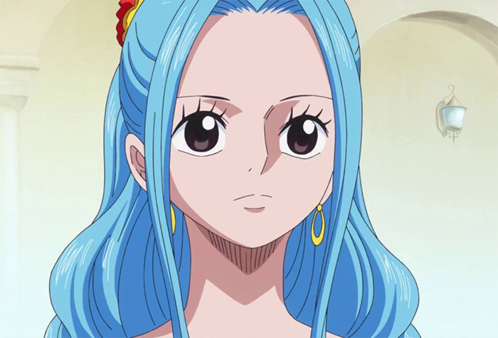 Female anime character with long blue hair and yellow earrings, standing in a well-lit room.