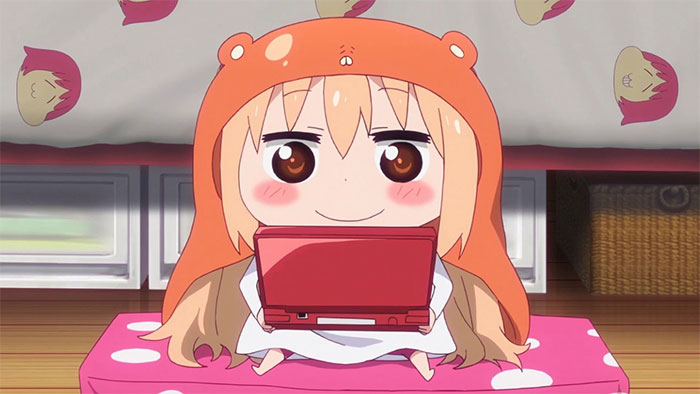 Cute female anime character wearing an orange hood, playing a red gaming console, sitting on a polka-dot cushion.