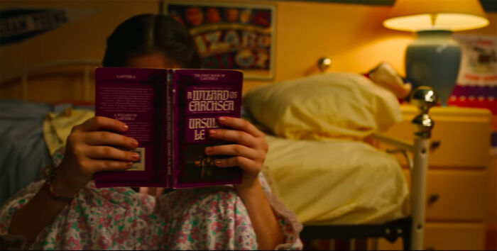 In Stranger Things The Book Dustin's Girlfriend Is Reading Shown Here Is Called "A Wizard Of Earthsea" Which Is About A Young Person With Magic Powers Who Accidentally Releases An Evil Being Into The World