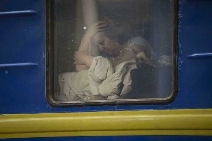 Mujer sentada junto a la ventana del tren que sale de Lviv. AP