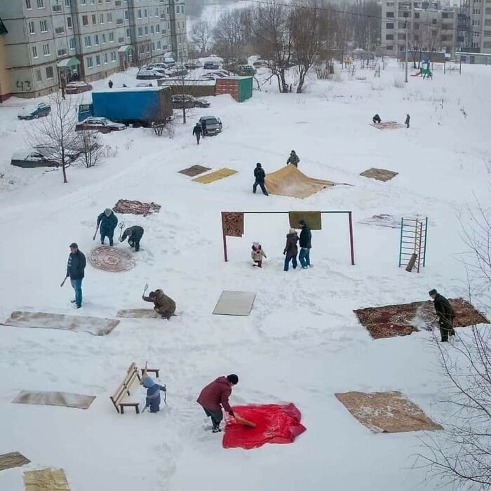 Polacos limpiando alfombras en la nieve