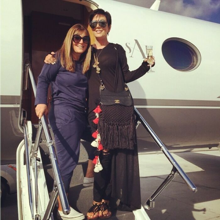 Kris Jenner On The Steps Of Her Private Jet, With A Glass Of Champagne