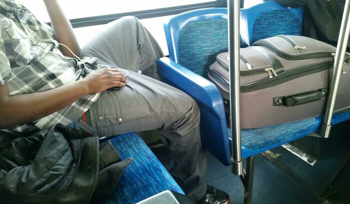 This Guy's Luggage And Coat Taking Up Three Seats On A Bus Where Other People Are Standing