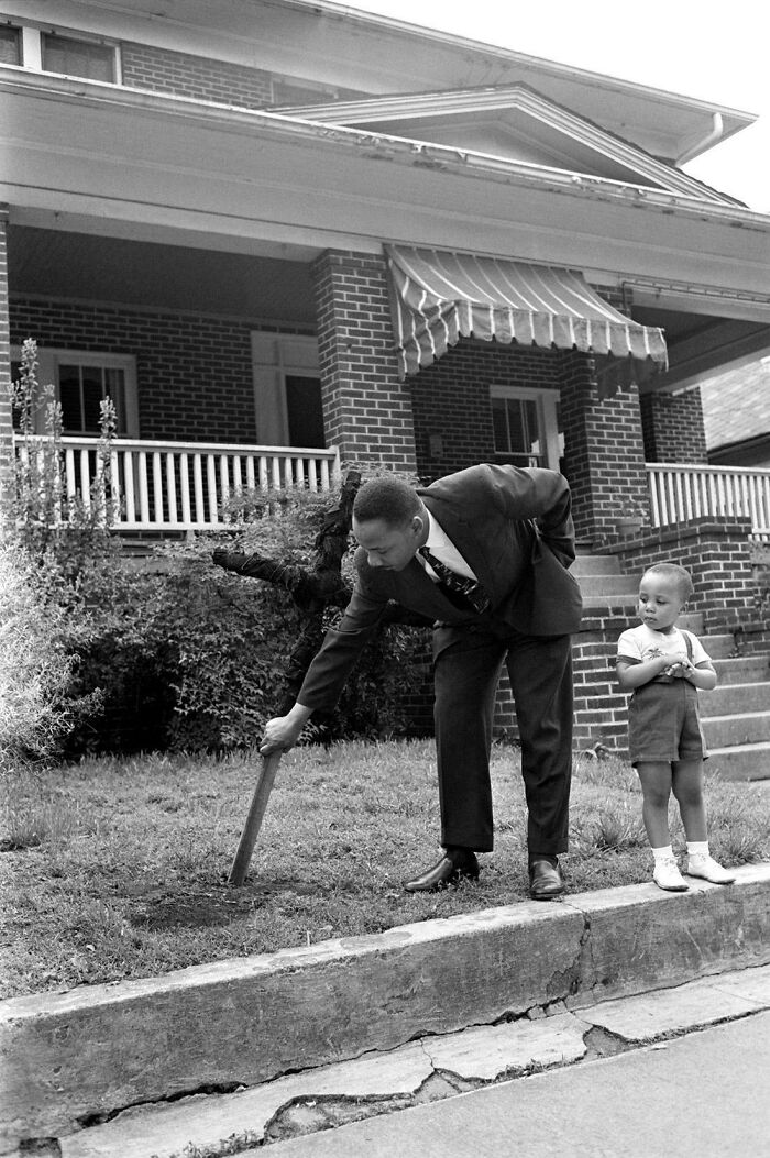 Martin Luther King Jr. con su hijo, sacando una cruz quemada del jardín delantero de su casa de Atlanta, abril de 1960