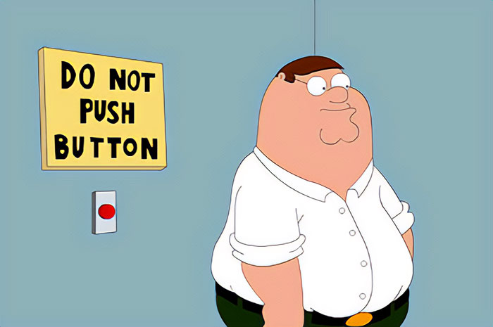 Family Guy character Peter Griffin standing near red button